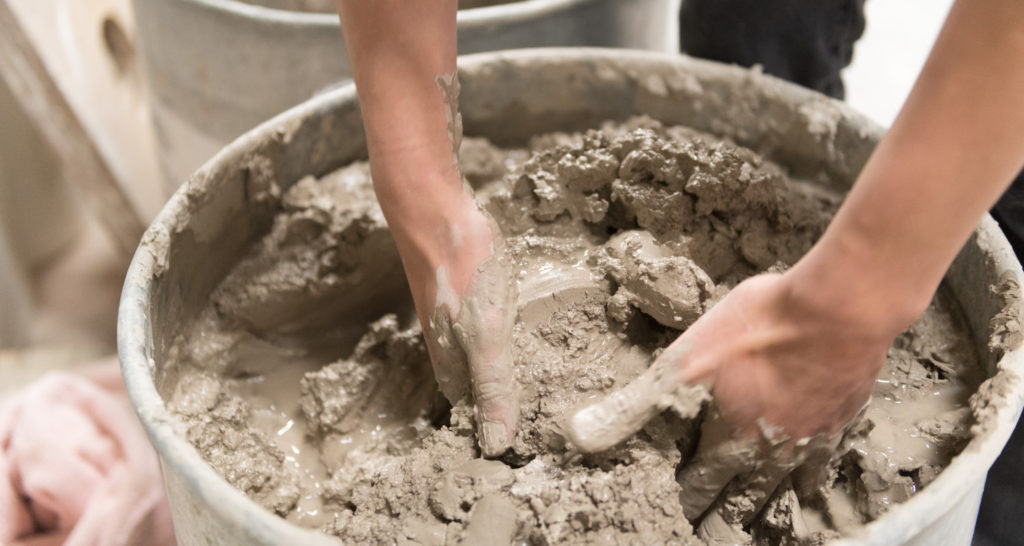 Student mixing clay