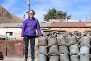 Mary Van Buren, standing next to bags of mineral ore in highland Bolivia