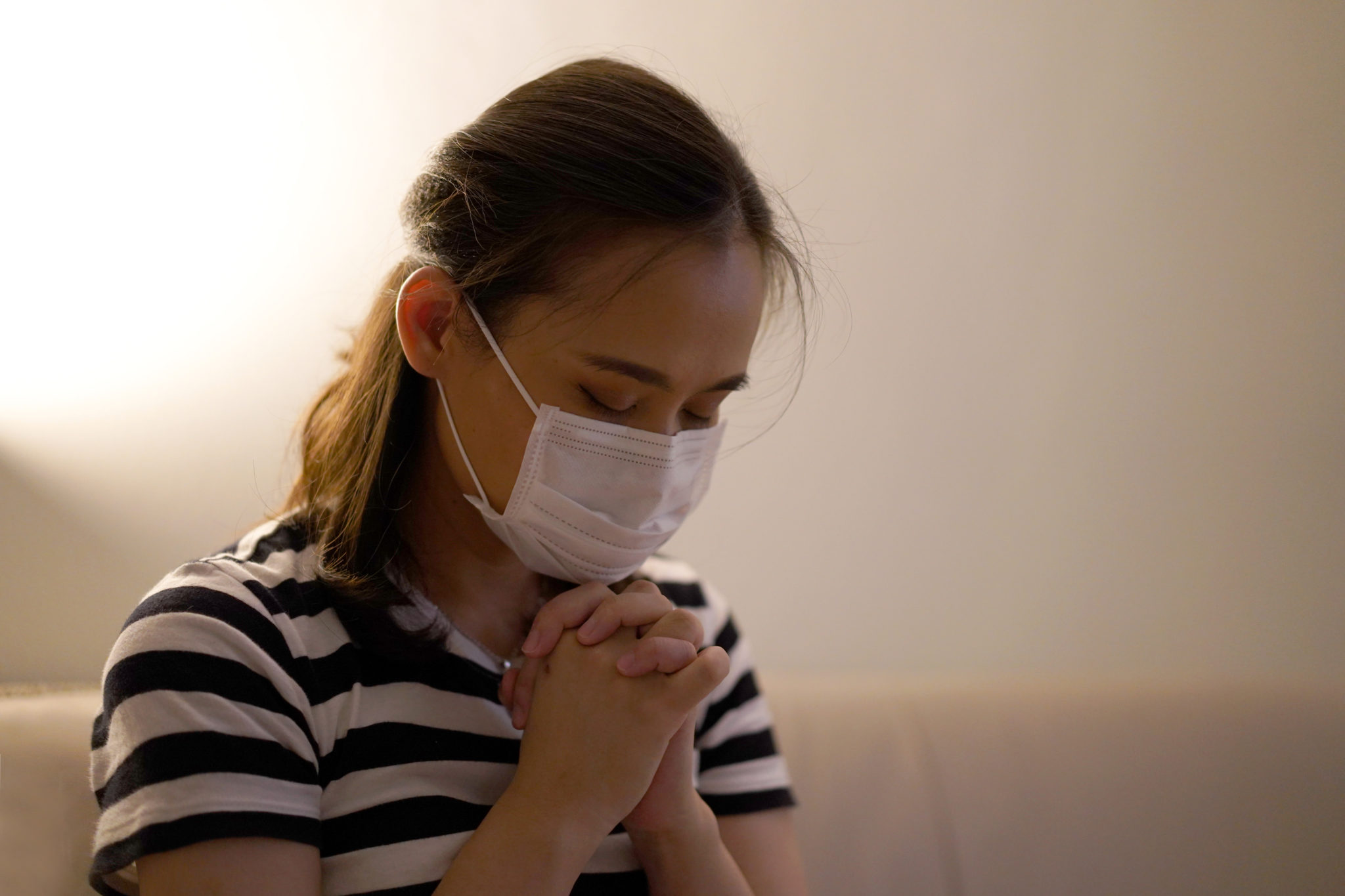 Woman in mask praying