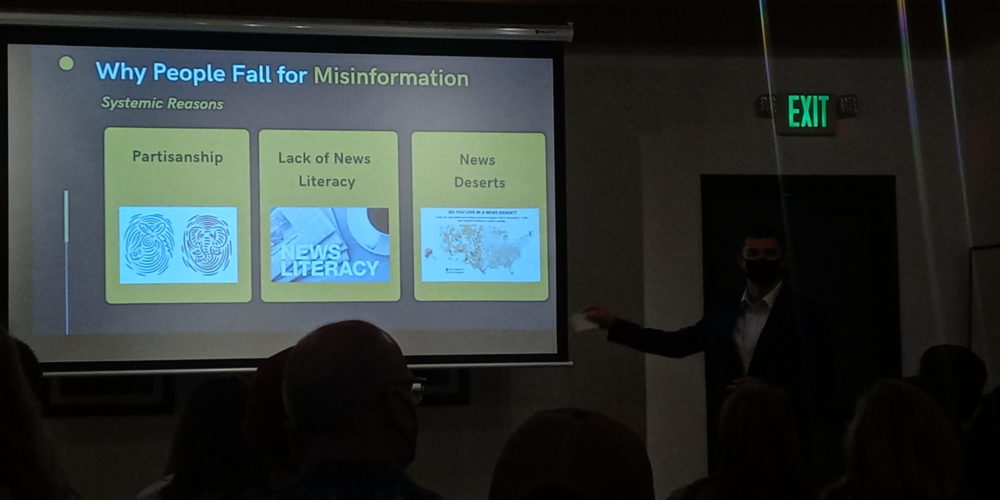 Political science student presenting on why people fall for misinformation, citing partisanship, lack of news literacy, and news deserts as the primary reasons