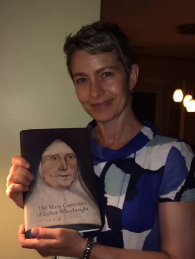 Ann Little holding her biography about Esther Wheelwright