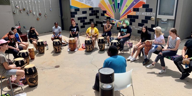 Photo of Social Justice Thru the Arts Students in a drum circle activity