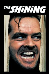 Movie poster for "The Shining" featuring a scary-looking man's grinning face sticking out from a broken door