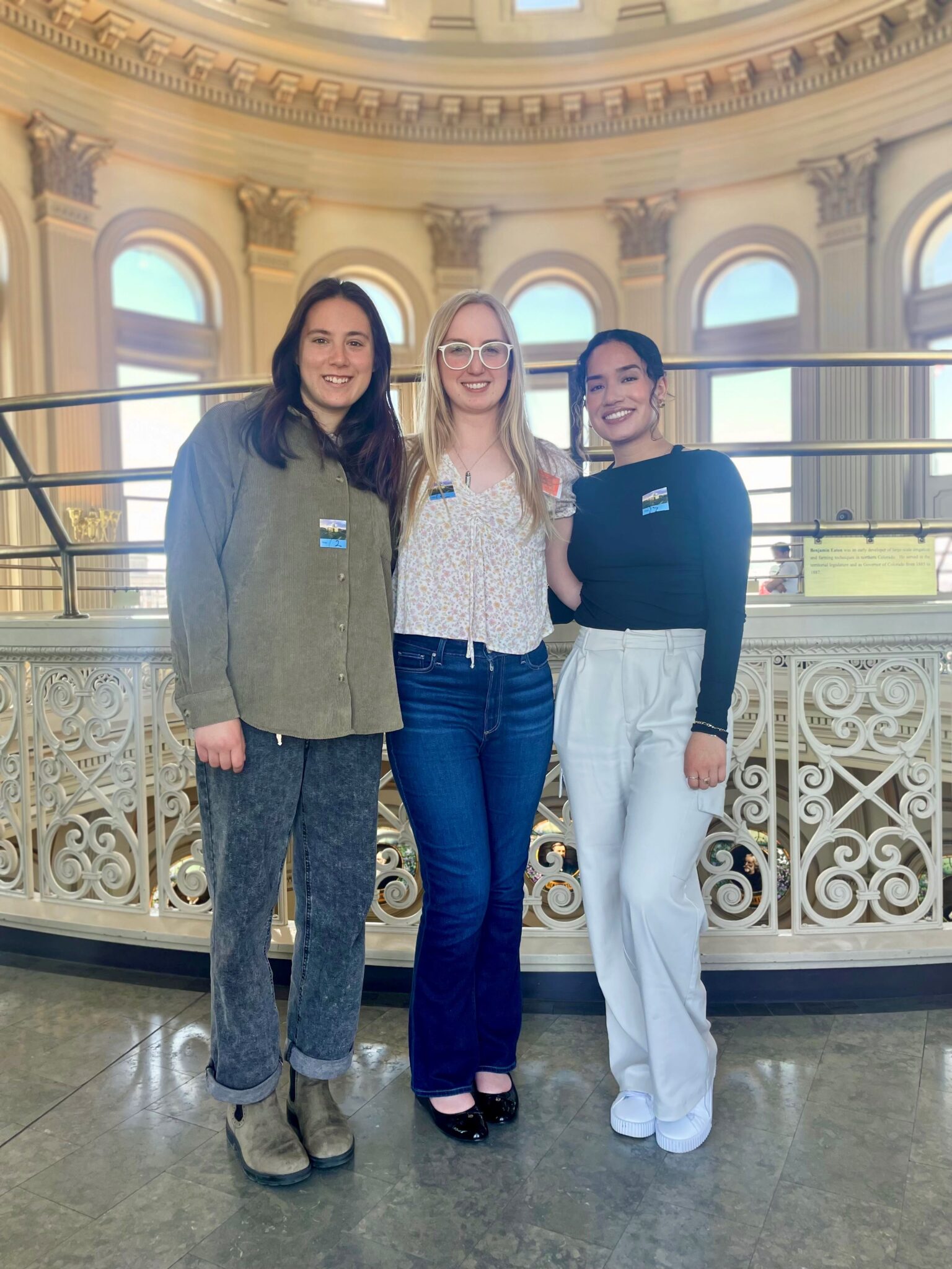 Three CSU students, Democracy Fellows for the 23-24 school year, stand in the Colorado State Capitol.